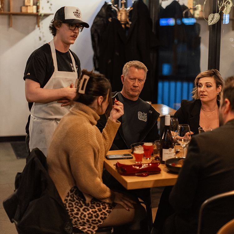 jordan explaining a dish at a chef's table event at vice & virtue brewing kelowna